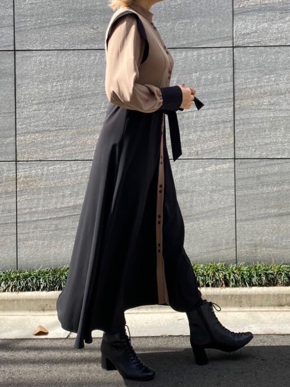 ベージュ系のワンピースを着用したレディースの冬コーディネートの2枚目の写真