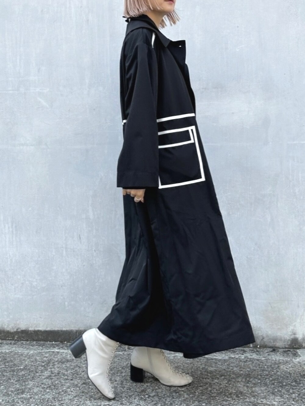 ブラック系のトレンチコートを着用したレディースの春コーディネートの3枚目の写真