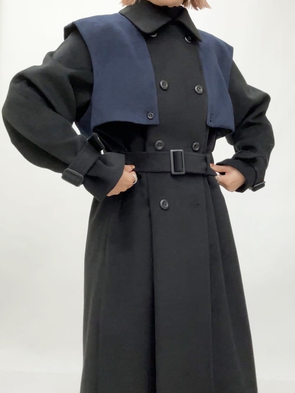 ブラック系のチェスターコートを着用したレディースの冬コーディネートの4枚目の写真