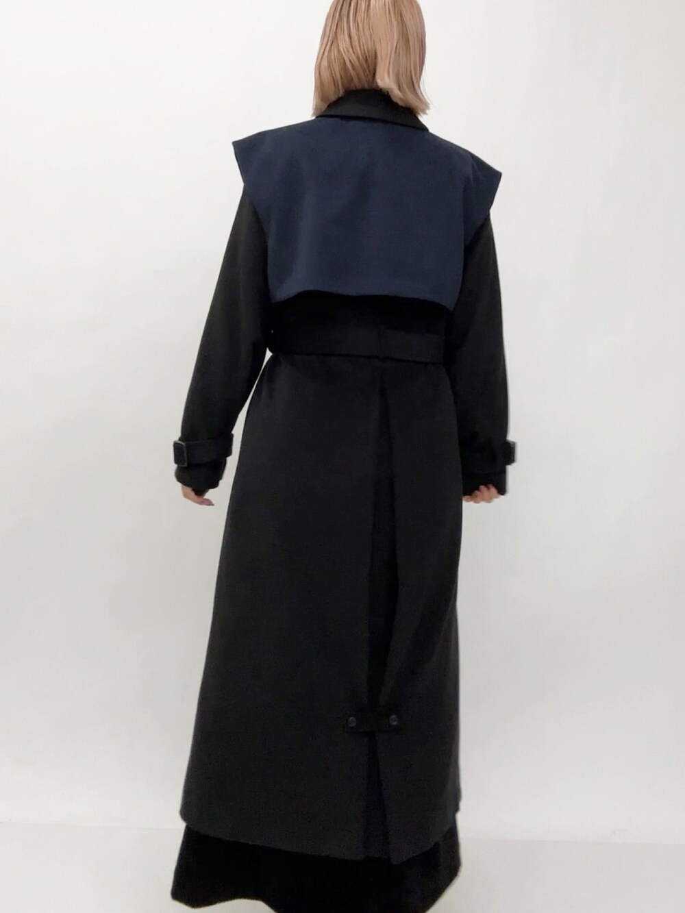 ブラック系のチェスターコートを着用したレディースの冬コーディネートの2枚目の写真