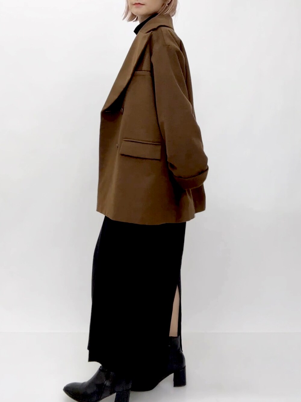 ブラウン系のチェスターコートを着用したレディースの冬コーディネートの5枚目の写真