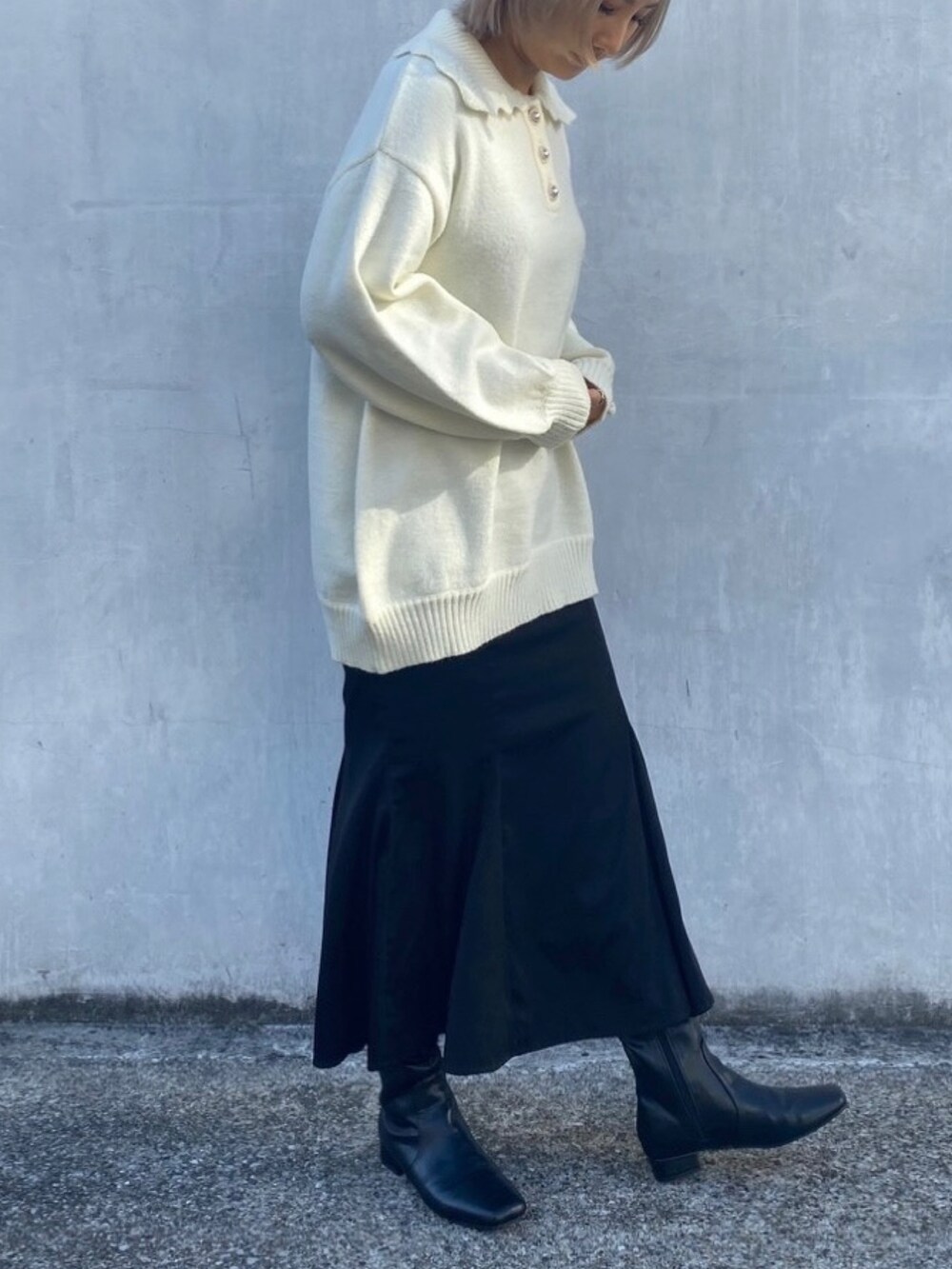 ホワイト系のニット/セーター、ブラック系のスカートを着用したレディースの冬コーディネートの4枚目の写真