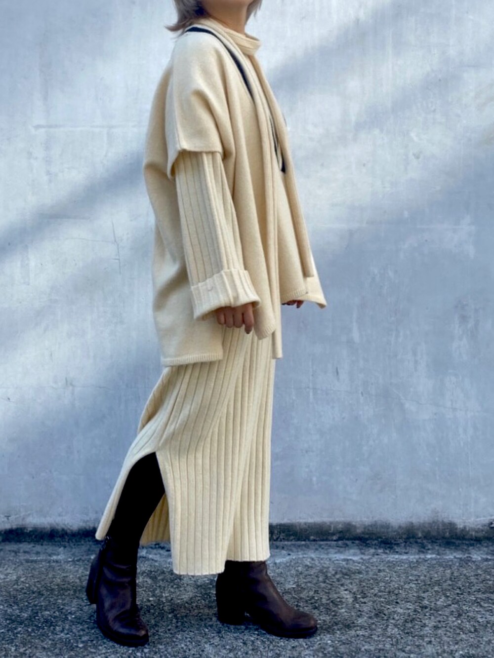 ホワイト系のニット/セーター、ホワイト系のワンピースを着用したレディースの冬コーディネートの4枚目の写真