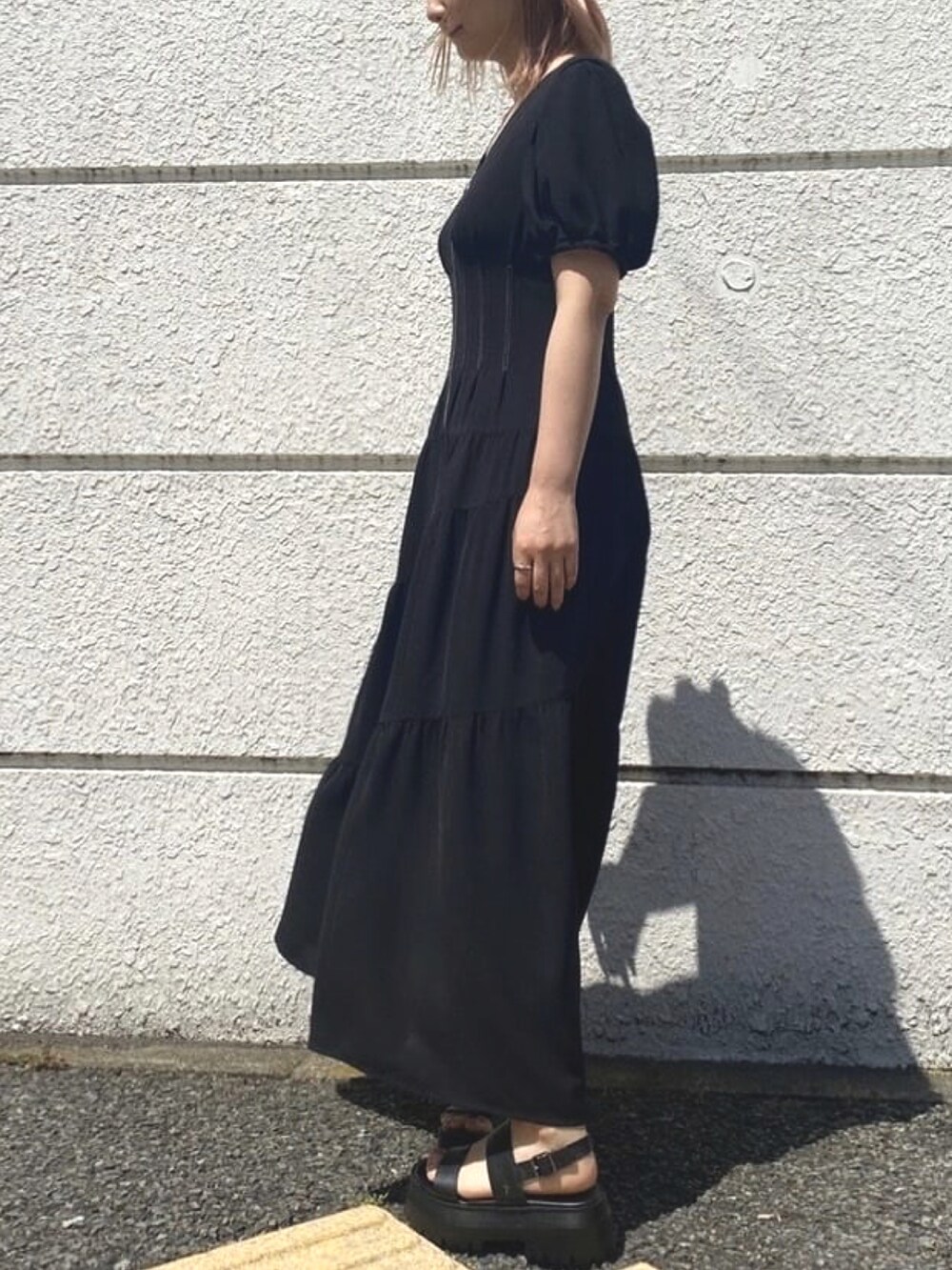 ブラック系のワンピースを着用したレディースの夏コーディネートの2枚目の写真