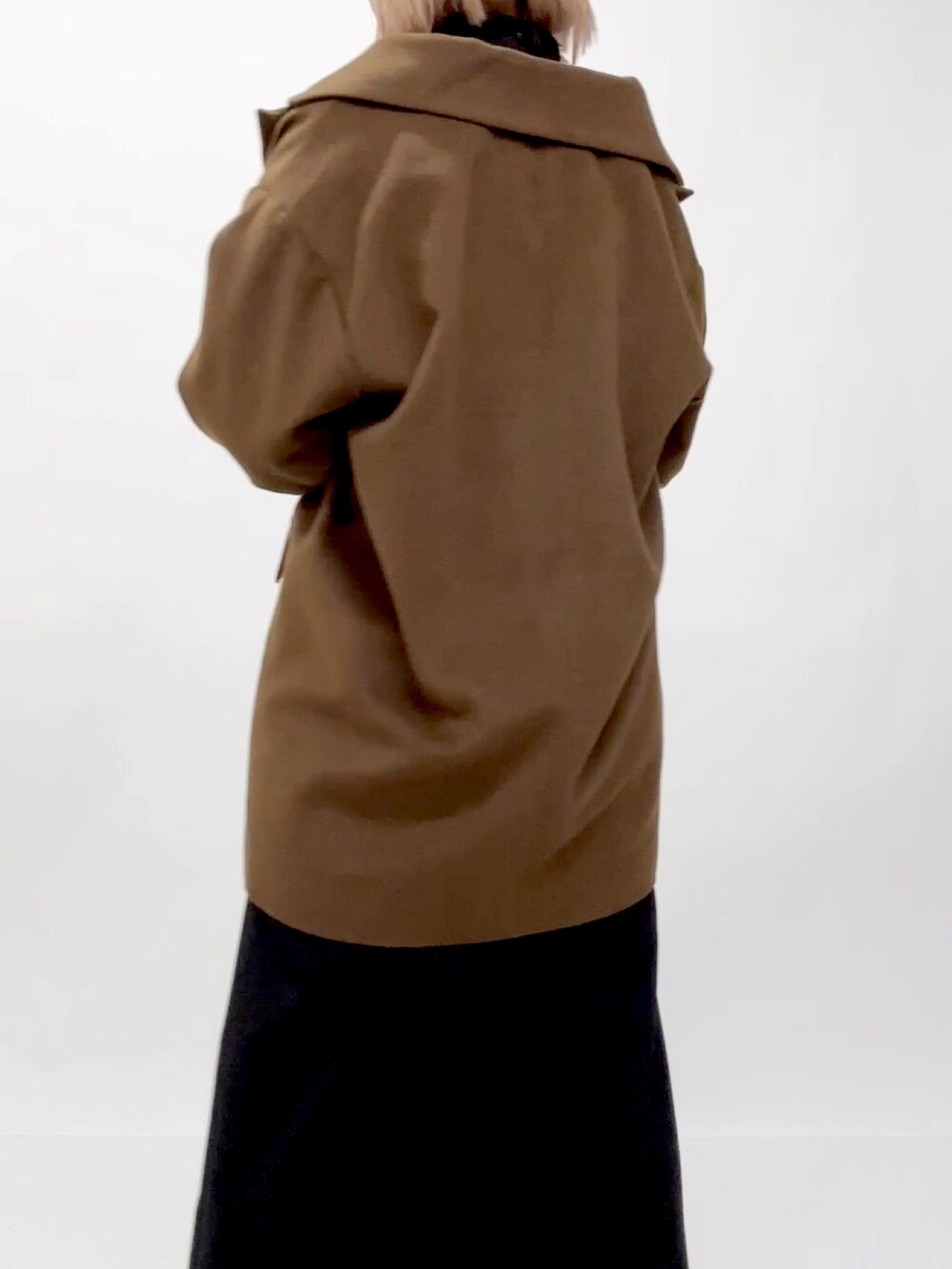 ブラウン系のチェスターコートを着用したレディースの冬コーディネートの2枚目の写真