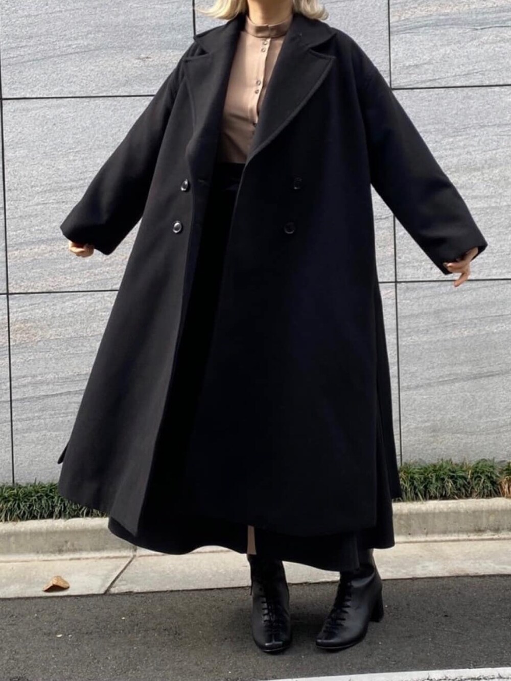 ベージュ系のワンピース、ブラック系のステンカラーコートを着用したレディースの冬コーディネートの4枚目の写真