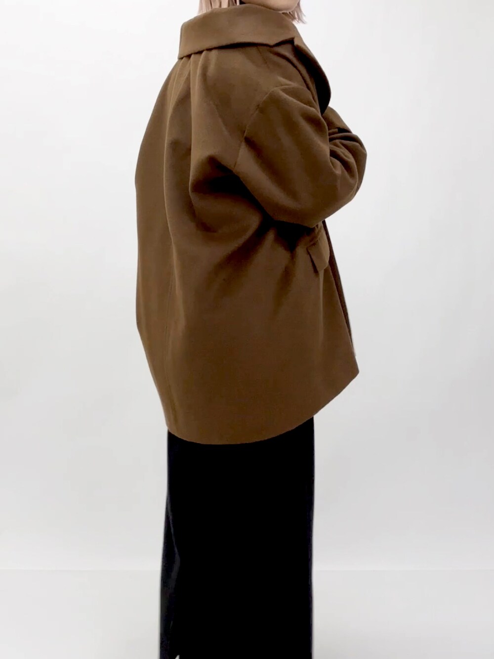 ブラウン系のチェスターコートを着用したレディースの冬コーディネートの3枚目の写真