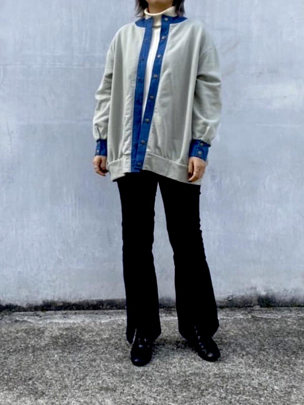 グリーン系のTシャツ/カットソー、ブルー系のデニムパンツを着用したレディースの冬コーディネートの2枚目の写真