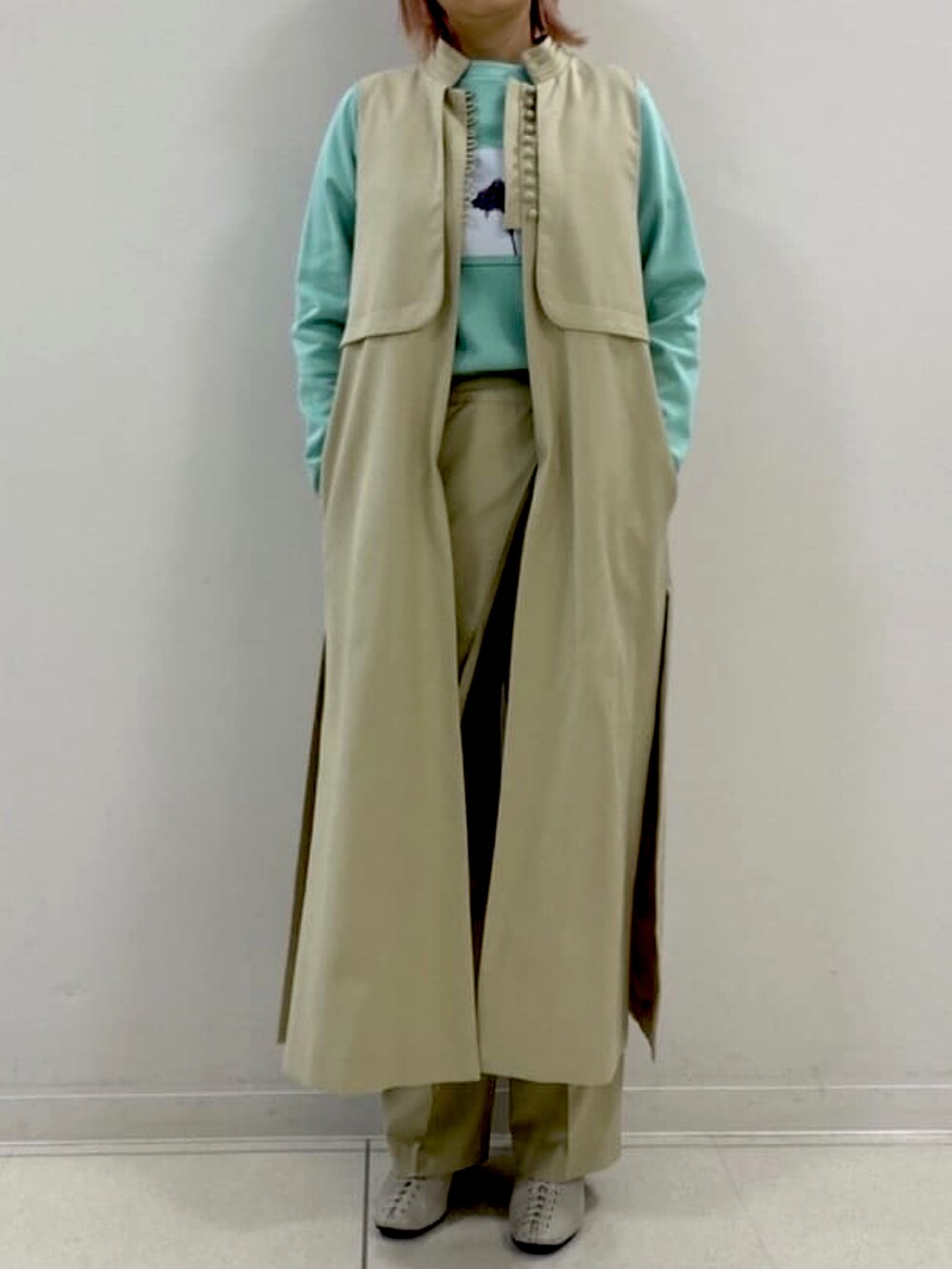 ベージュ系のその他アウター、グリーン系のTシャツ/カットソー、ベージュ系のその他パンツを着用したレディースの春コーディネートの2枚目の写真