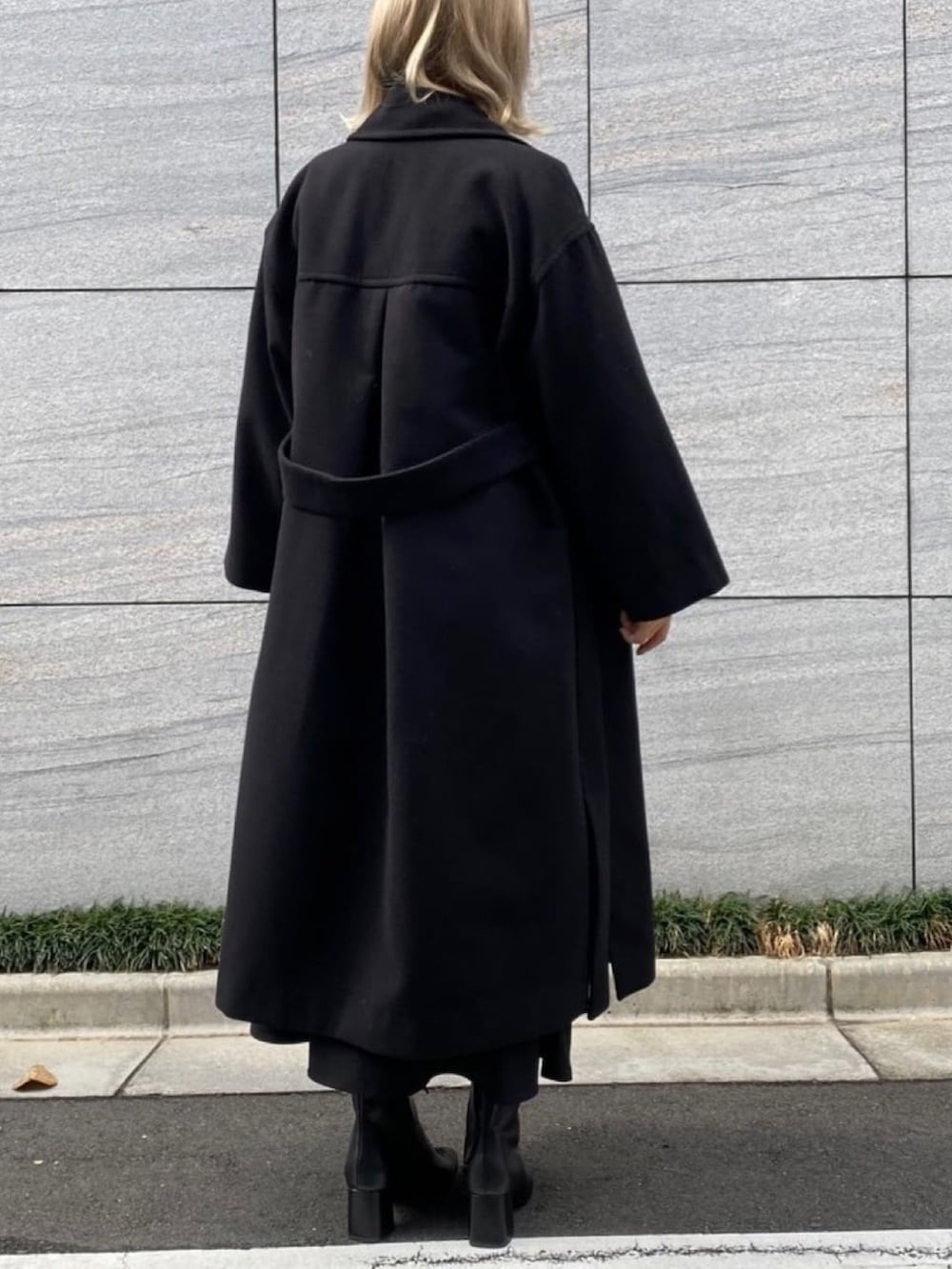 ベージュ系のワンピース、ブラック系のステンカラーコートを着用したレディースの冬コーディネートの3枚目の写真