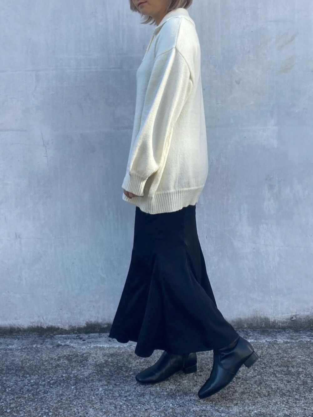 ホワイト系のニット/セーター、ブラック系のスカートを着用したレディースの冬コーディネートの2枚目の写真