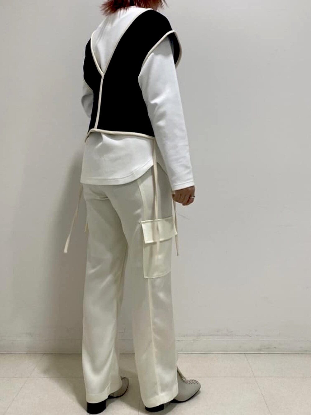 ブラック系のニット/セーター、ホワイト系のTシャツ/カットソー、ホワイト系のカーゴパンツを着用したレディースの春コーディネートの2枚目の写真