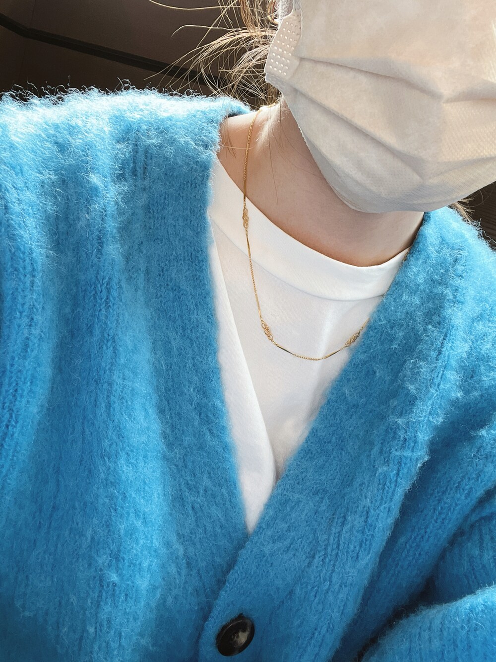 ブルー系のニット/セーターを着用したレディースの冬コーディネートの2枚目の写真