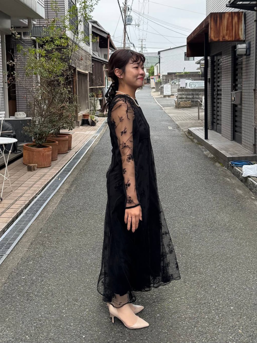 ブラック系のワンピースを着用したレディースの秋コーディネートの2枚目の写真