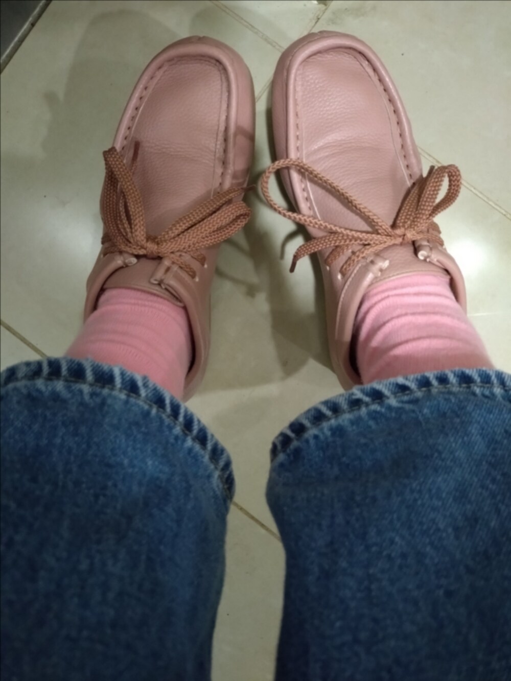 ブルー系のデニムパンツ、ピンク系のニット/セーター、ピンク系のハンドバッグを着用したレディースの秋コーディネートの3枚目の写真