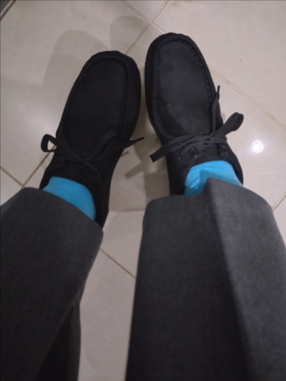 グレー系のハンドバッグ、グレー系のスラックス、ブルー系のカーディガン/ボレロを着用したレディースの秋コーディネートの3枚目の写真