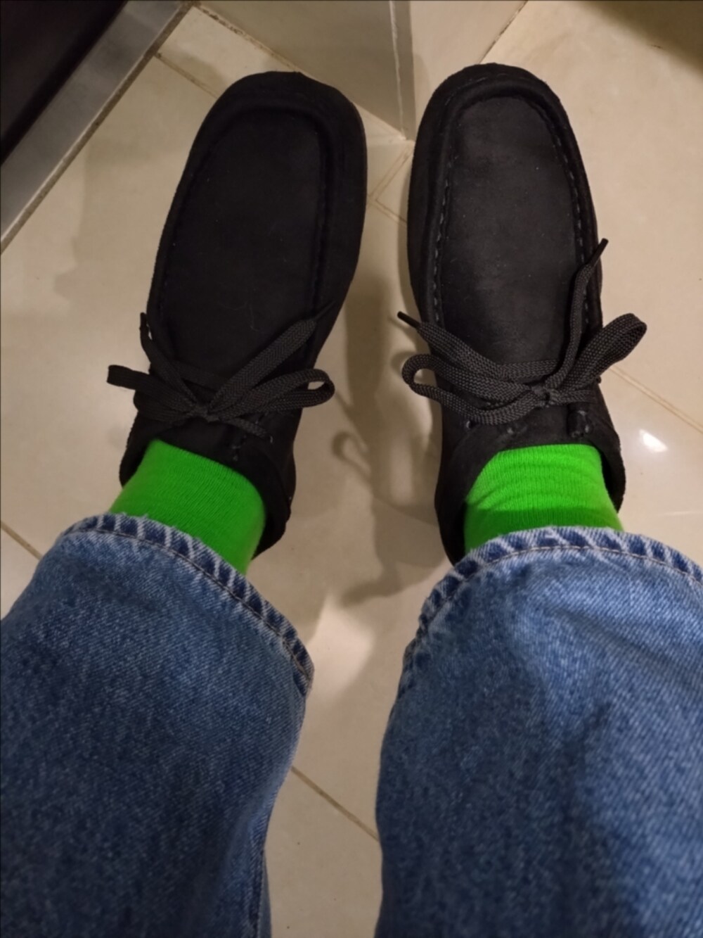 ブルー系のデニムパンツ、ホワイト系のトートバッグ、グリーン系のニット/セーターを着用したレディースの秋コーディネートの4枚目の写真