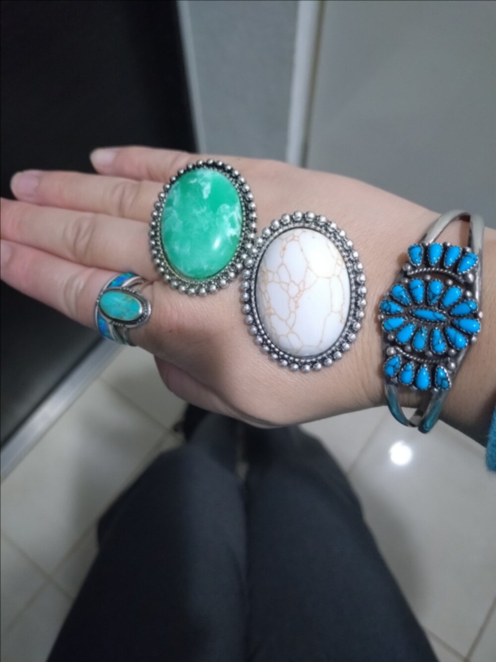 グレー系のハンドバッグ、グレー系のスラックス、ブルー系のカーディガン/ボレロを着用したレディースの秋コーディネートの2枚目の写真