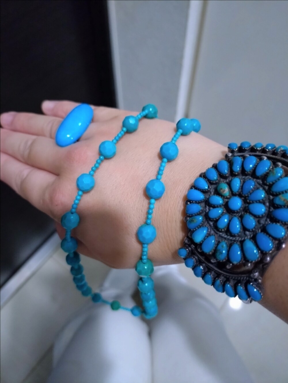 ホワイト系のデニムパンツ、ホワイト系のショルダーバッグ、ブルー系のバングル/リストバンドを着用したレディースの秋コーディネートの2枚目の写真