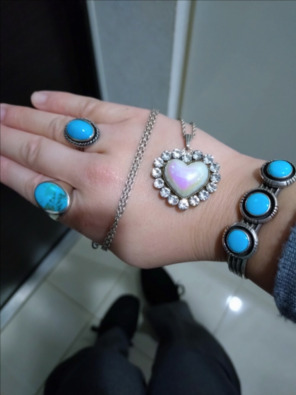 グレー系のスラックス、ブラック系のトートバッグ、グレー系のニット/セーターを着用したレディースの冬コーディネートの2枚目の写真