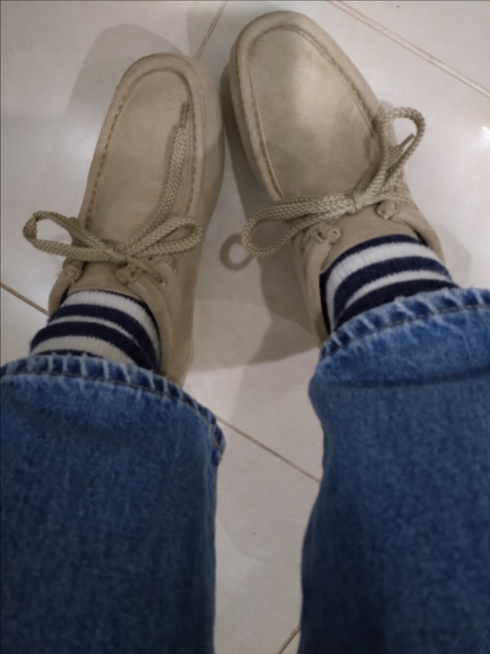 ブルー系のデニムパンツ、ベージュ系のトートバッグ、ブルー系のニット/セーターを着用したレディースの冬コーディネートの3枚目の写真