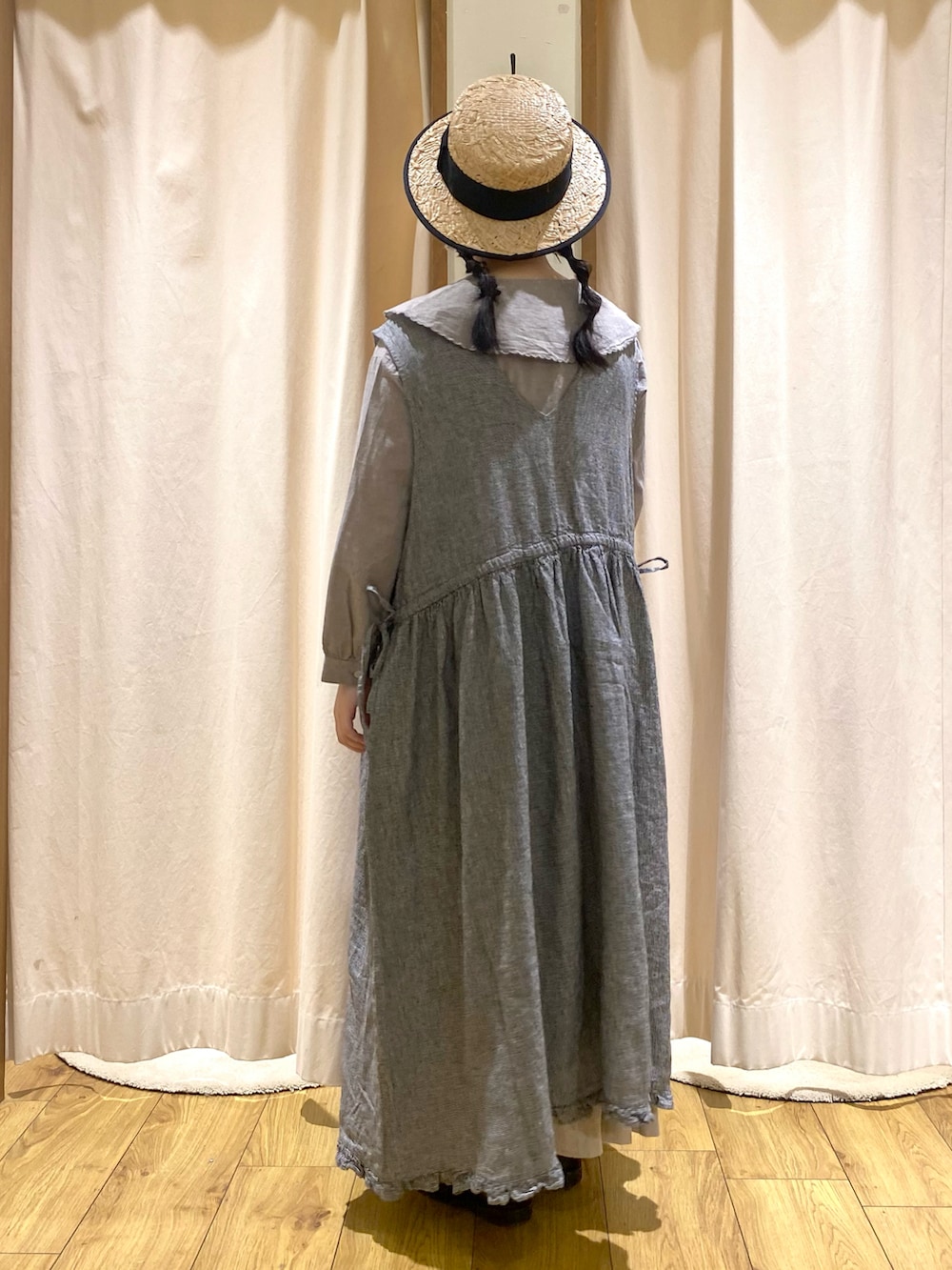 グレー系のシャツ/ブラウス、グレー系のスカート、ブラック系のワンピースを着用したレディースの春コーディネートの2枚目の写真