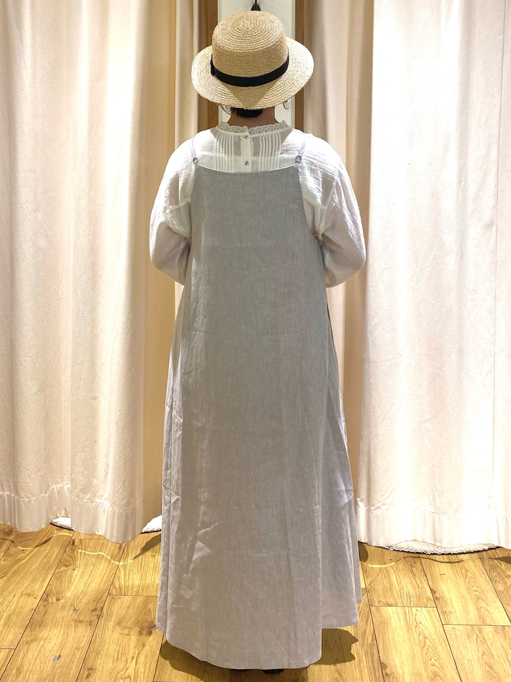 グレー系のワンピース、ホワイト系のシャツ/ブラウス、ブラック系のハットを着用したレディースの春コーディネートの3枚目の写真