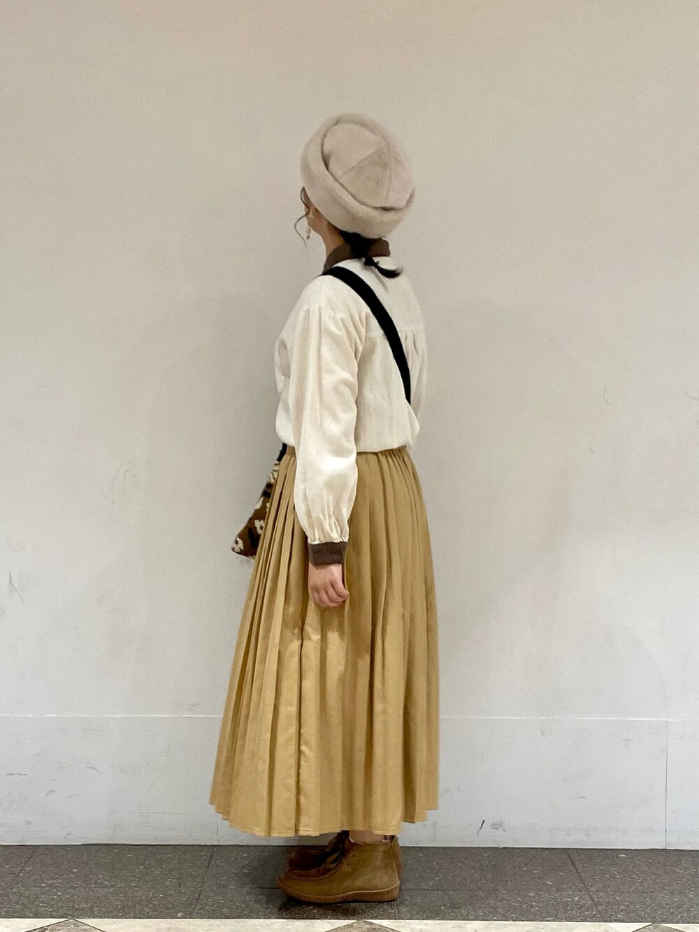 ホワイト系のシャツ/ブラウス、ベージュ系のスカート、ホワイト系のハットを着用したレディースの秋コーディネートの2枚目の写真