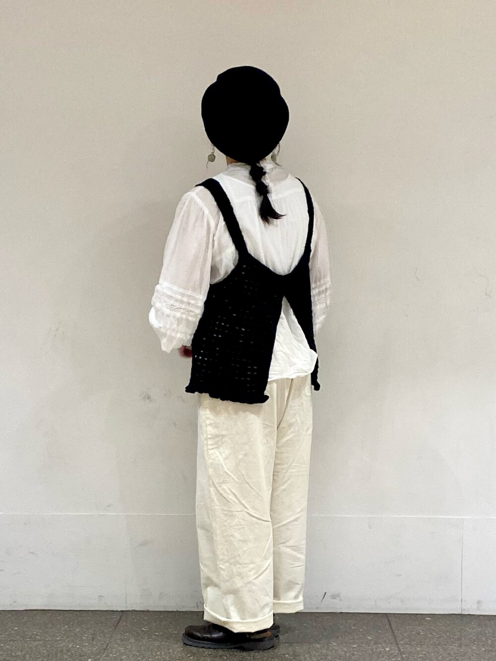 ブラック系のベスト、ホワイト系のシャツ/ブラウス、グリーン系のイヤリングを着用したレディースの春コーディネートの2枚目の写真