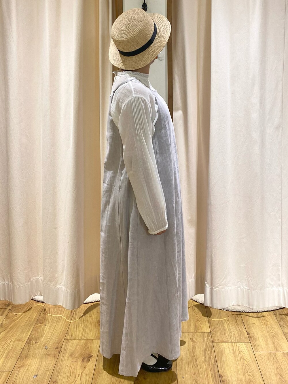 グレー系のワンピース、ホワイト系のシャツ/ブラウス、ブラック系のハットを着用したレディースの春コーディネートの2枚目の写真