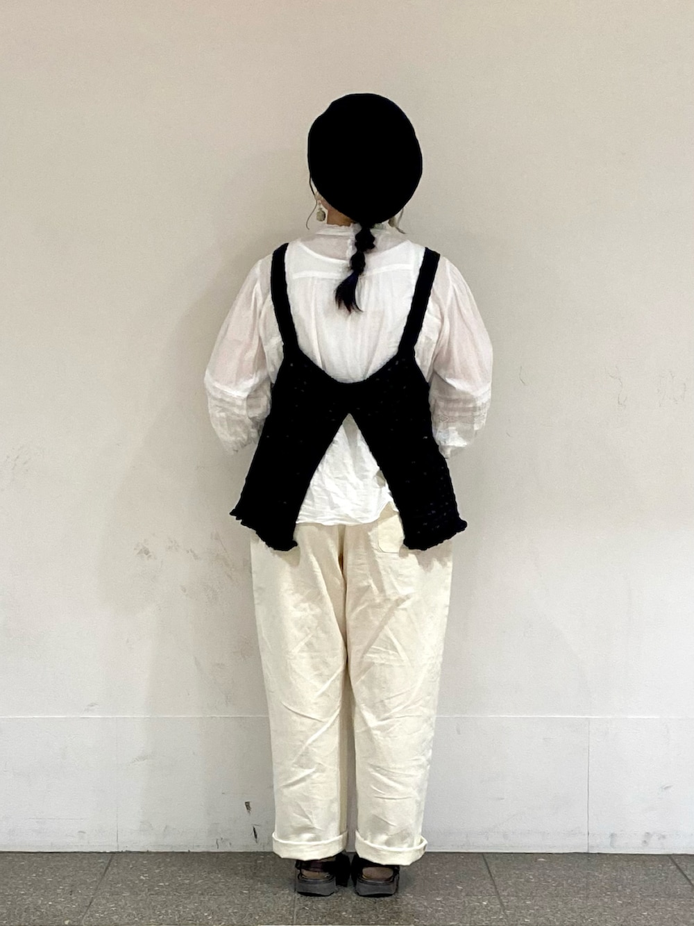 ブラック系のベスト、ホワイト系のシャツ/ブラウス、グリーン系のイヤリングを着用したレディースの春コーディネートの3枚目の写真