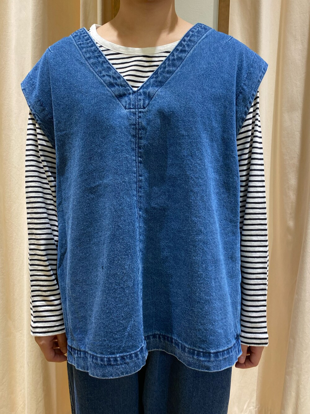 ブルー系のベスト、ブルー系のデニムパンツ、ホワイト系のTシャツ/カットソーを着用したレディースの冬コーディネートの3枚目の写真