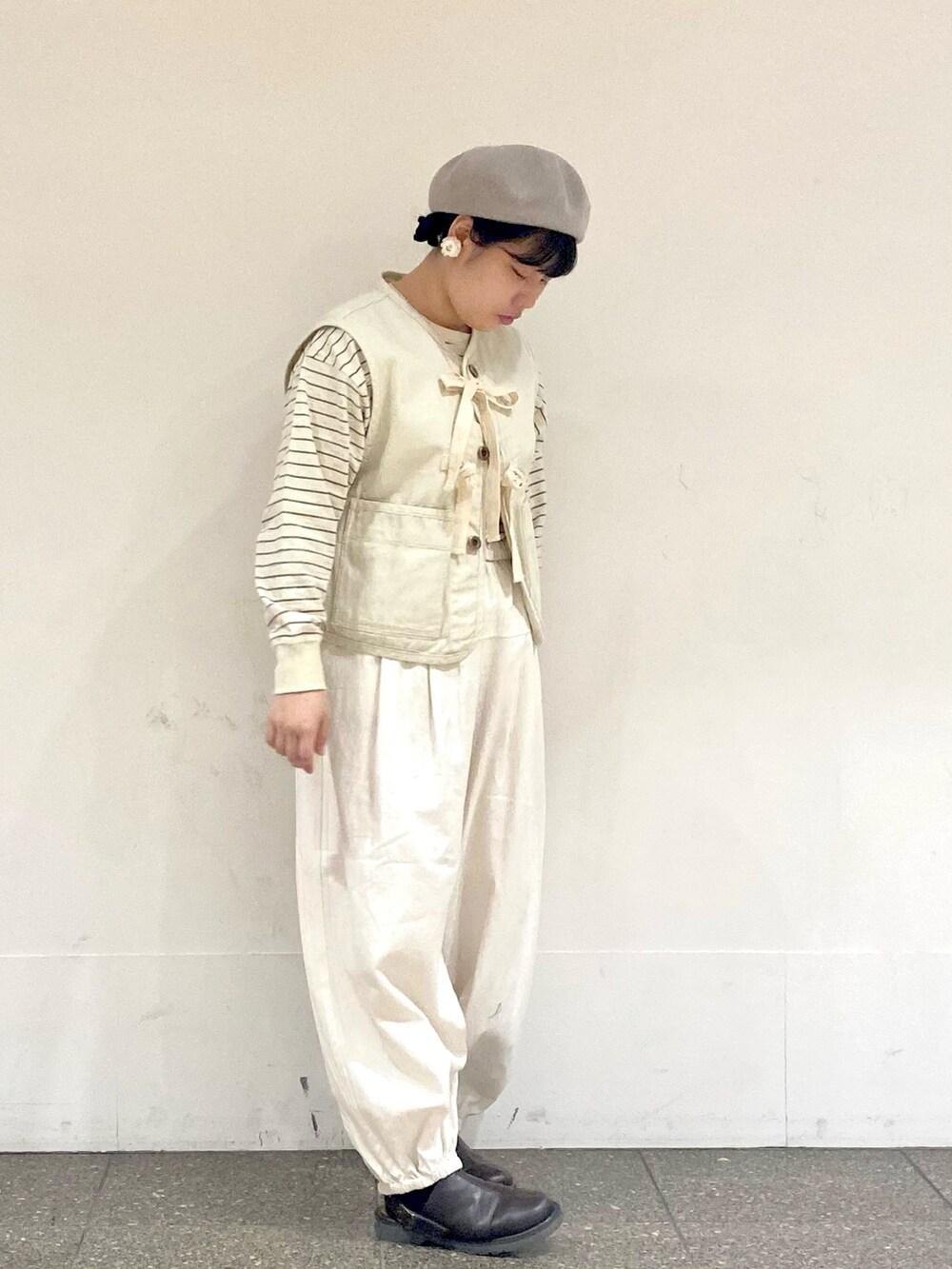 ベージュ系のTシャツ/カットソー、ホワイト系のベスト、ホワイト系のその他パンツを着用したレディースの冬コーディネートの2枚目の写真