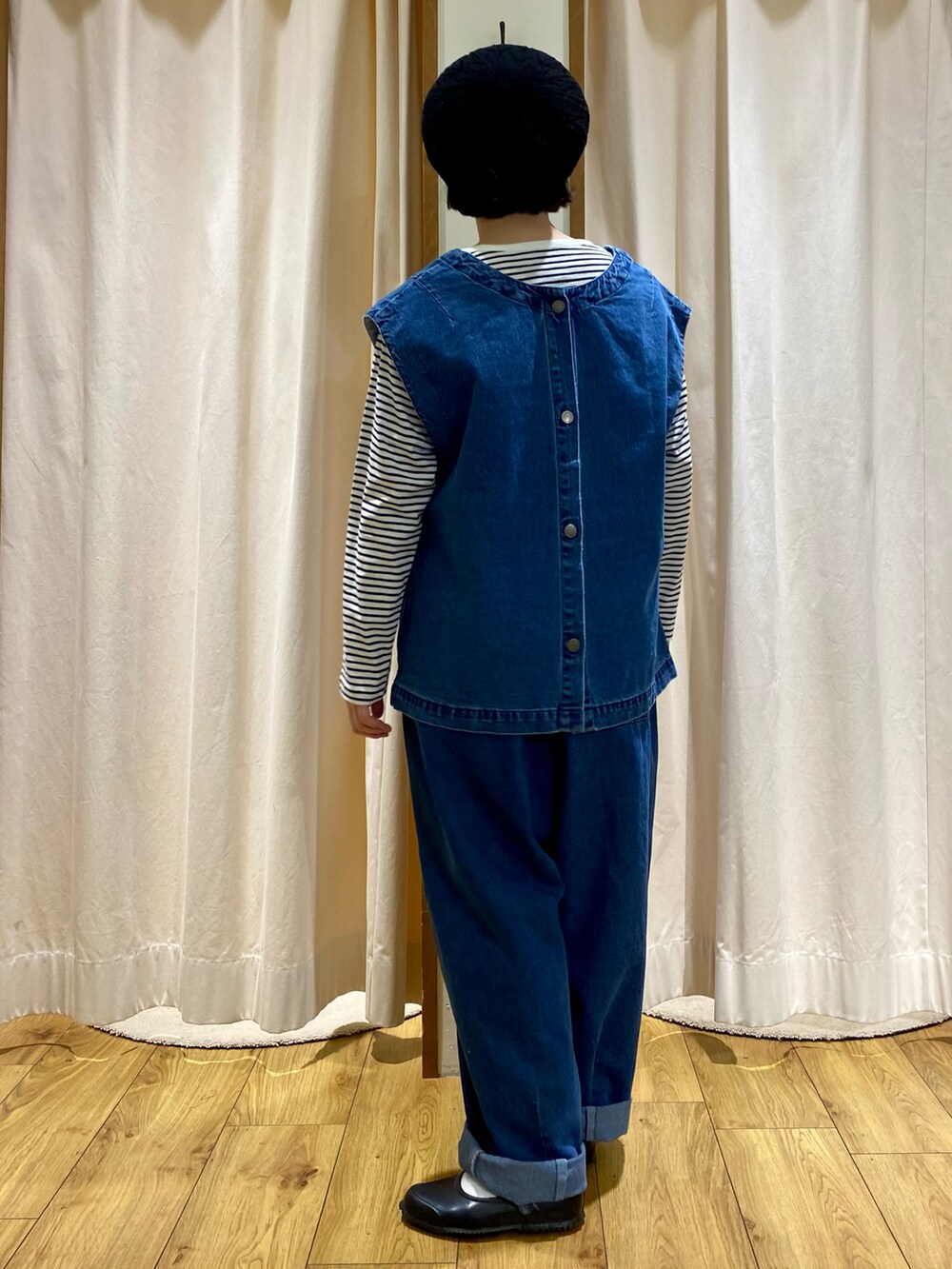 ブルー系のベスト、ブルー系のデニムパンツ、ホワイト系のTシャツ/カットソーを着用したレディースの冬コーディネートの2枚目の写真