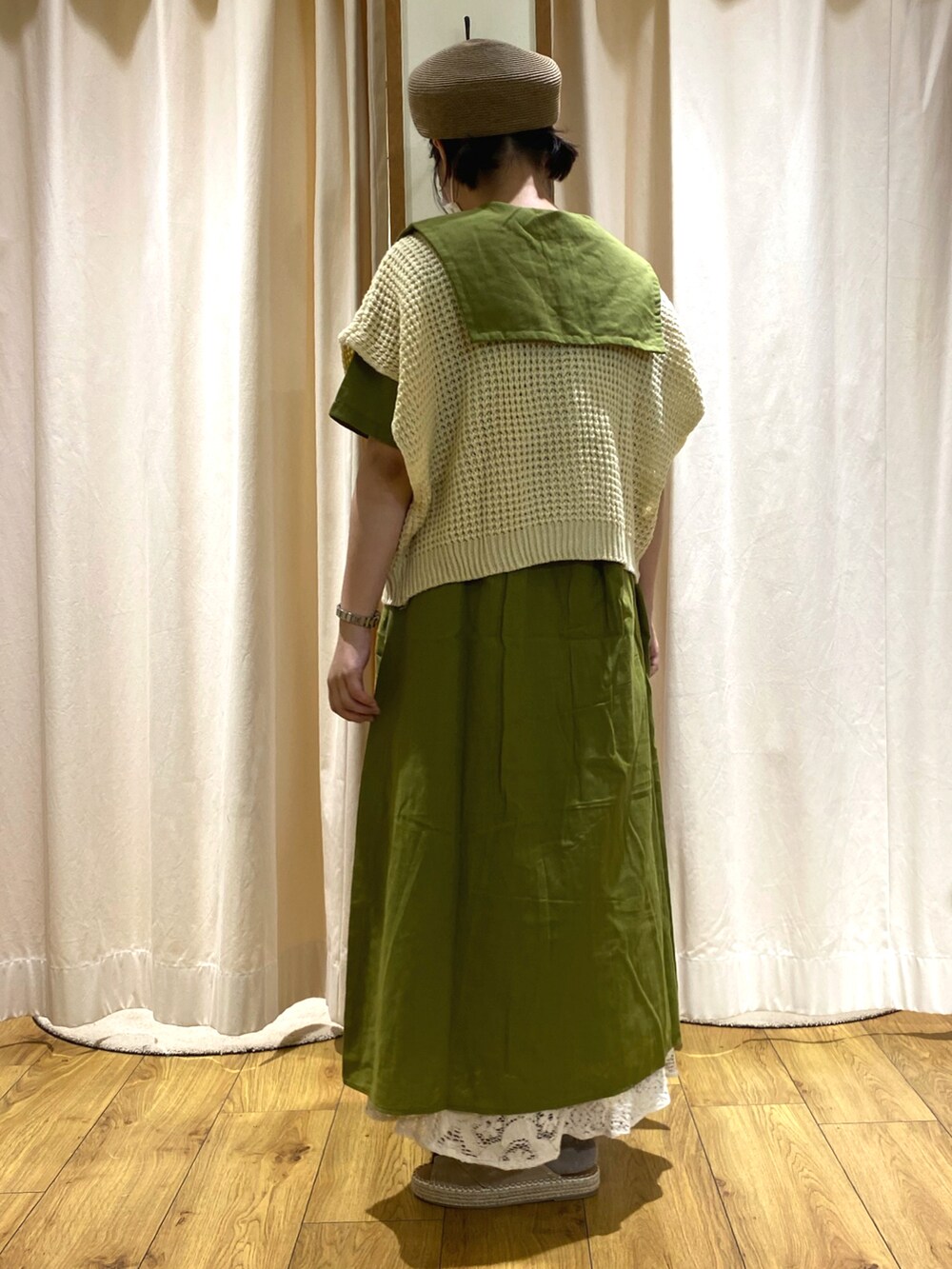 ベージュ系のサンダル、ホワイト系のスカート、ベージュ系のベストを着用したレディースの夏コーディネートの2枚目の写真