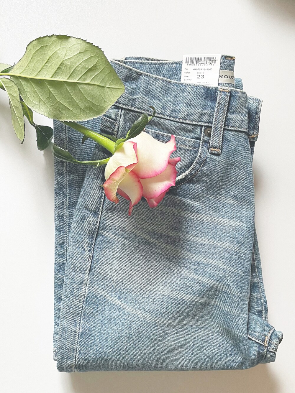 ブルー系のデニムパンツ、ホワイト系のニット/セーター、ホワイト系のブーツを着用したレディースの春コーディネートの3枚目の写真