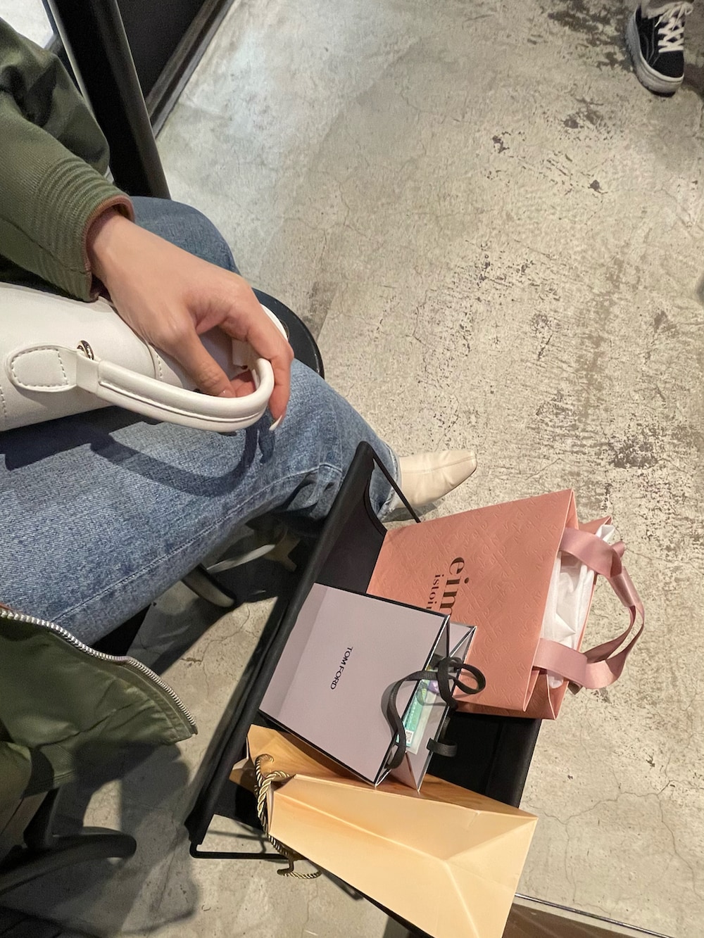 ブルー系のデニムパンツ、ホワイト系のニット/セーター、ホワイト系のブーツを着用したレディースの春コーディネートの2枚目の写真