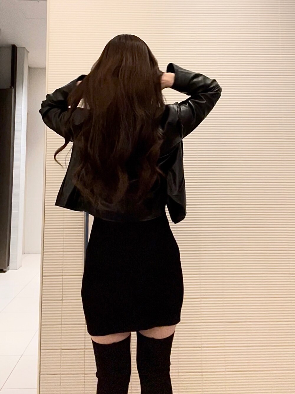 ブラック系のライダースジャケット、ブラック系のワンピースを着用したレディースの秋コーディネートの2枚目の写真