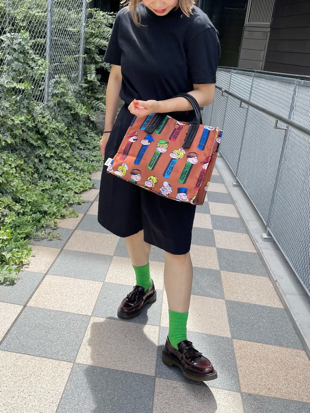 ベージュ系のトートバッグを着用したレディースの夏コーディネートの2枚目の写真