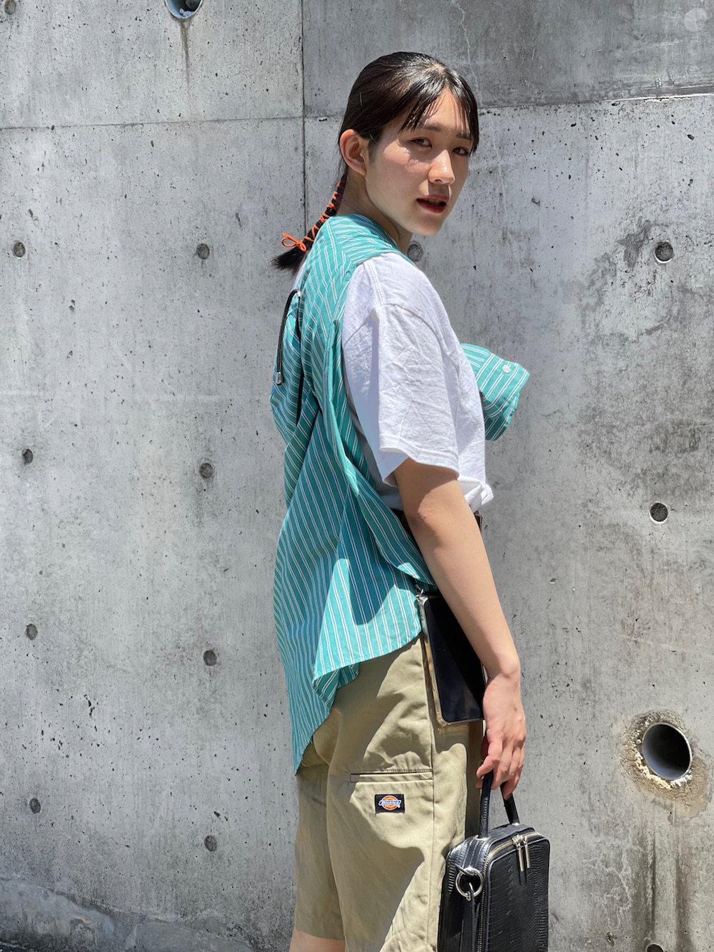 ブラック系のショルダーバッグ、グリーン系のシャツ/ブラウス、ベージュ系のチノパンツを着用したレディースの夏コーディネートの2枚目の写真