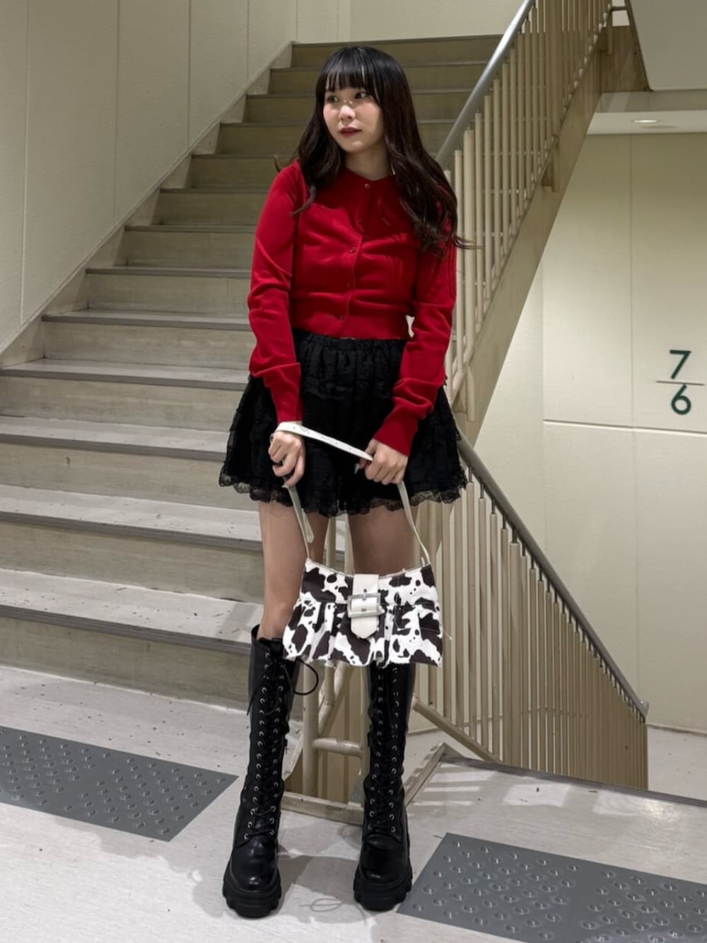 ブラック系のブーツ、ホワイト系のハンドバッグ、ブラック系のその他パンツを着用したレディースの春コーディネートの3枚目の写真