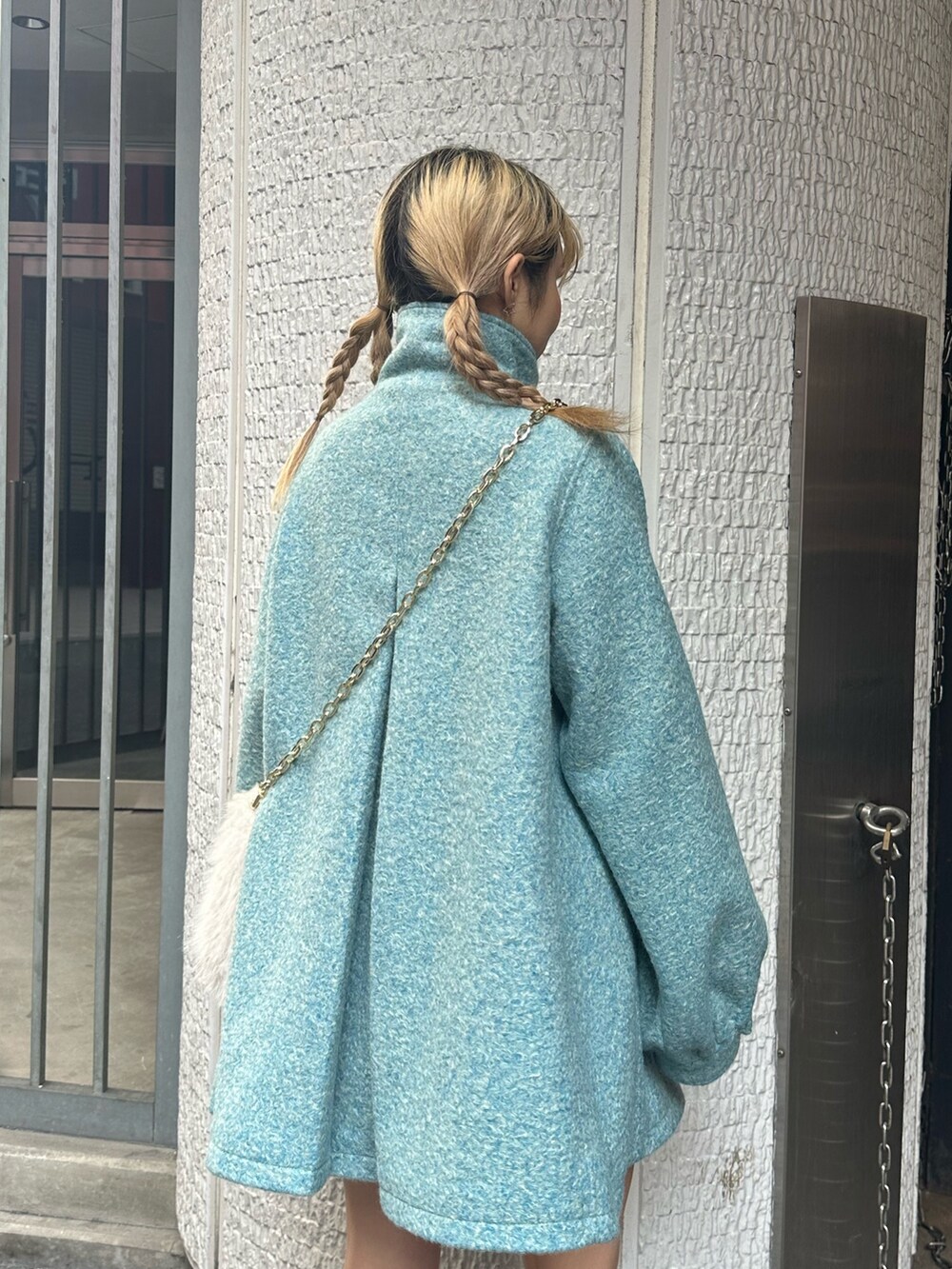 ブルー系のその他アウター、ホワイト系のハンドバッグ、ブラック系のブーツを着用したレディースの冬コーディネートの4枚目の写真