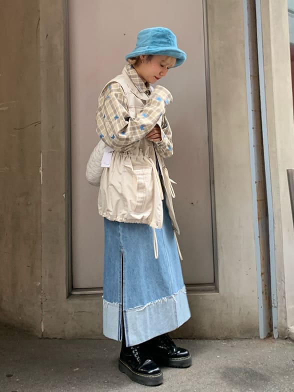 ブルー系のデニムスカート、ベージュ系のシャツ/ブラウス、ホワイト系のベストを着用したレディースの秋コーディネートの2枚目の写真