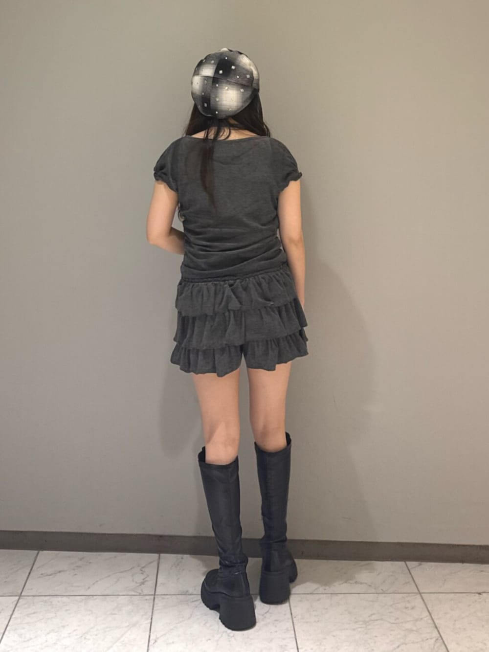 ブラック系のブーツ、グレー系のTシャツ/カットソー、グレー系のスカートを着用したレディースの夏コーディネートの3枚目の写真