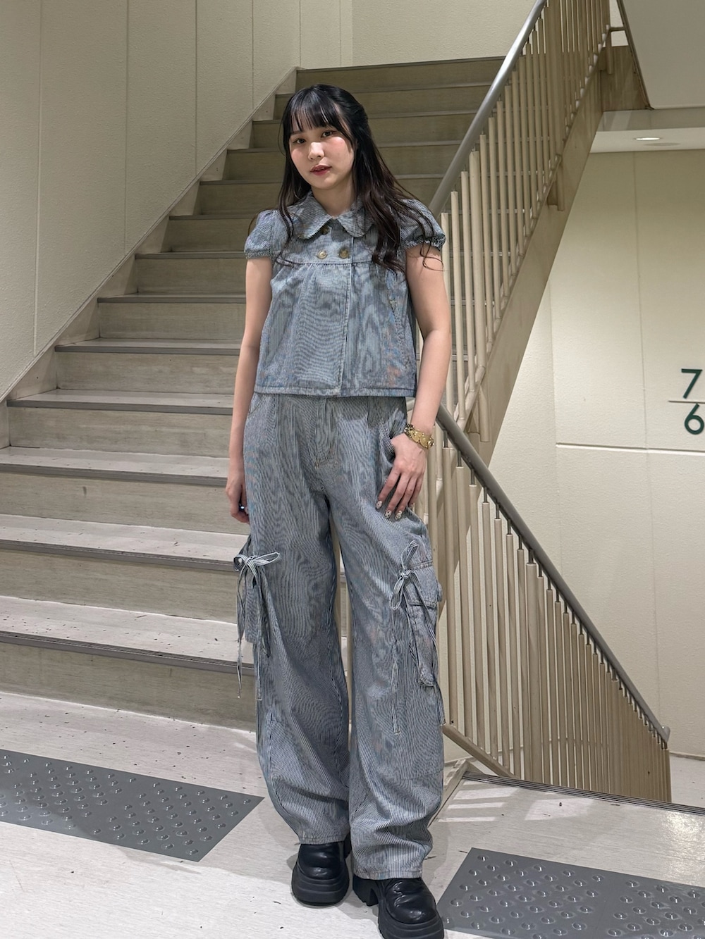 ブラック系のデニムパンツ、ブラック系のブーツ、ブラック系のその他トップスを着用したレディースの春コーディネートの6枚目の写真
