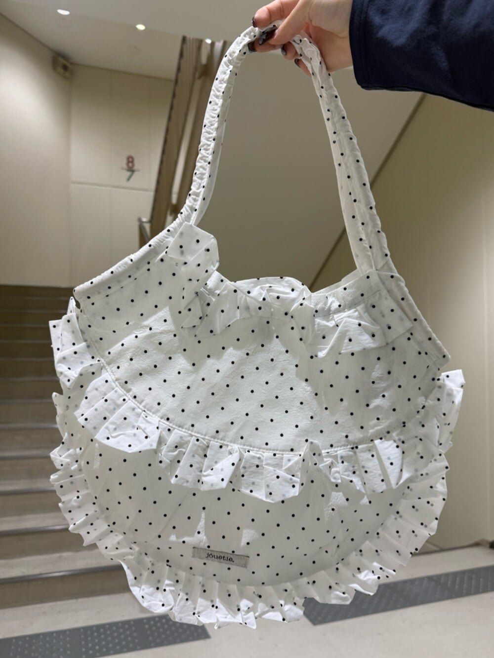 ブラック系のブーツ、ブラウン系のブルゾン、ホワイト系のワンピースを着用したレディースの冬コーディネートの9枚目の写真