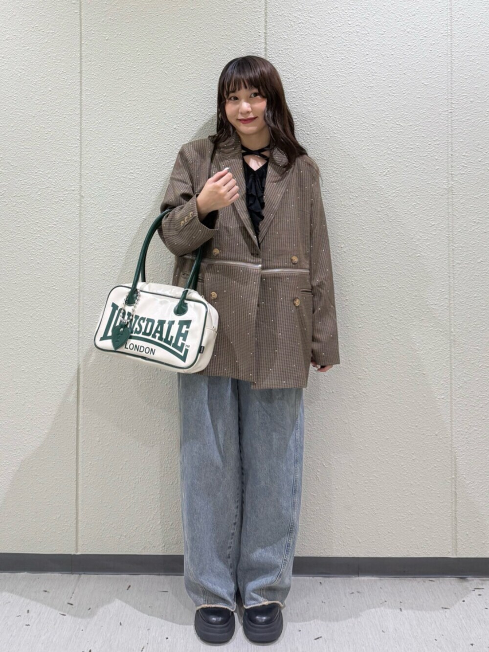 ブラウン系のテーラードジャケット、ブラック系のTシャツ/カットソー、ホワイト系のボストンバッグを着用したレディースの秋コーディネートの4枚目の写真