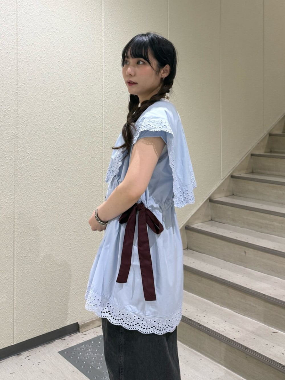 ブラック系のブーツ、ブラック系のデニムパンツ、ホワイト系のタンクトップを着用したレディースの夏コーディネートの6枚目の写真