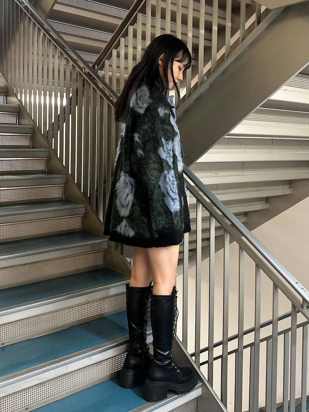 グレー系のスカート、ブラック系のニット/セーター、ブルー系のシャツ/ブラウスを着用したレディースの秋コーディネートの3枚目の写真