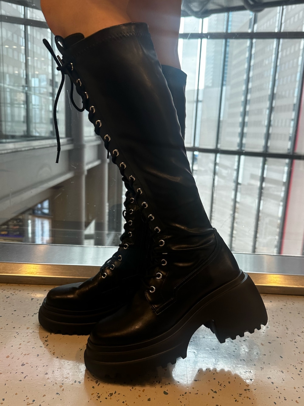 ホワイト系のシャツワンピース、ブルー系のハンドバッグ、ブラック系のブーツを着用したレディースの夏コーディネートの8枚目の写真